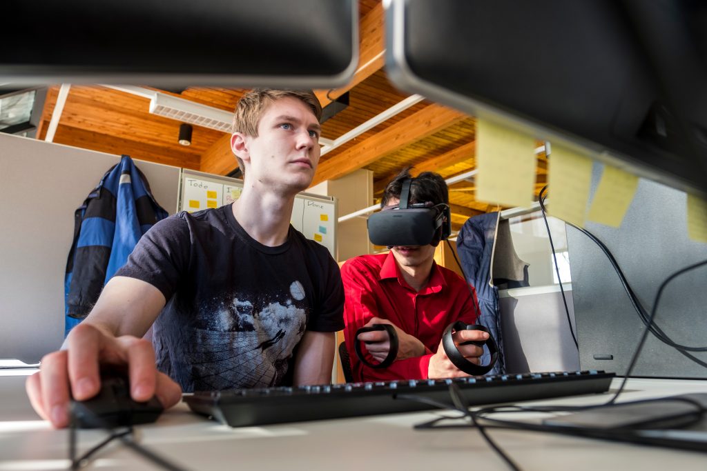 Students Eli Most ('18), a computer science major (black shirt), and Zachary Segall ('18), a math and computer science double major (red shirt), work in the new Grinnell College Immersive Experiences Lab on April 4, 2018. (Photo by Justin Hayworth/Grinnell College)